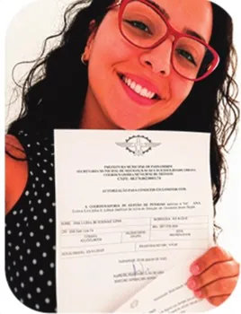 Ana Luísa segurando documento de convocação como professora, 2019